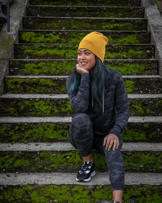 Žena ve sportovně elegantním outfitu s vestou a teniskami